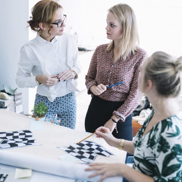 creative-team-businesswomen-preparing-checkered-flag-office creative-team-businesswomen-preparing-checkered-flag-office
