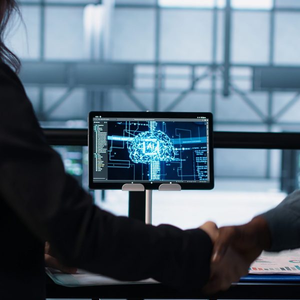 Manager meeting with client in data center to review files, doing handshake Manager meeting with client in data center to review files, doing handshake after finalizing deal. Server room supervisor reaching agreement with customer after checking documentation, camera A